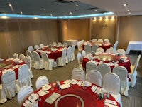 a banquet room with red and white tables and chairs